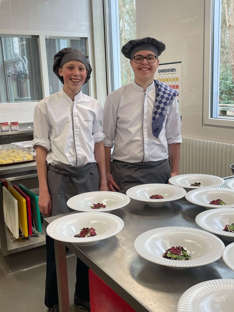 Twee jongens poseren in de keuken met lekkere hapjes