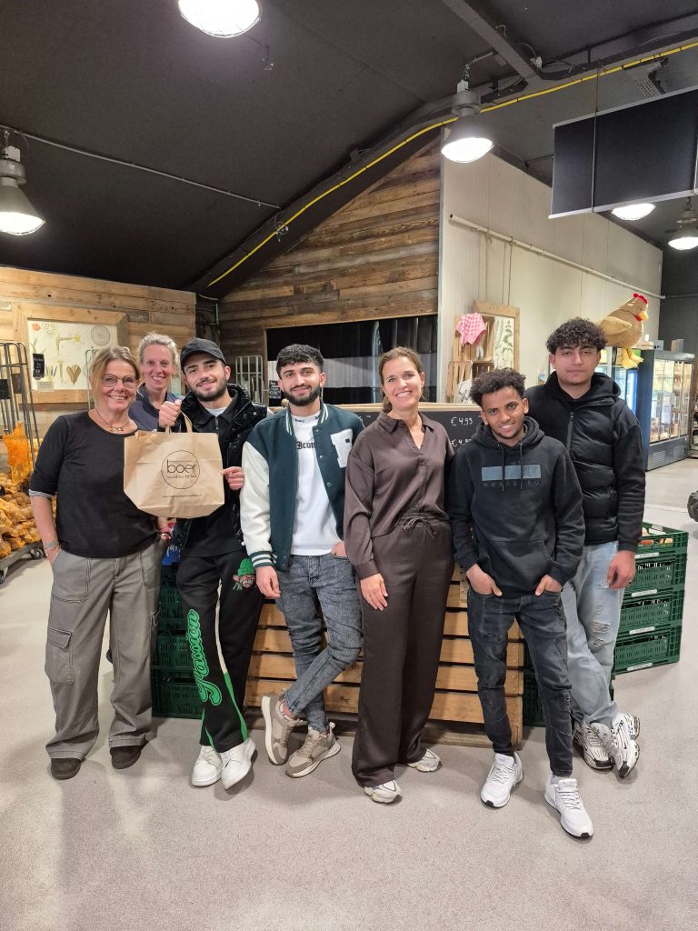 Groep bezoekers poseert vrolijk bij Boer, Winkel van het Land
