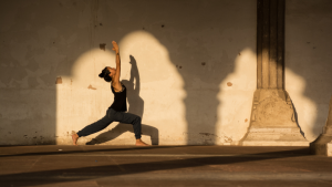 dame staat in yogapose in de zon bij een authentieke locatie