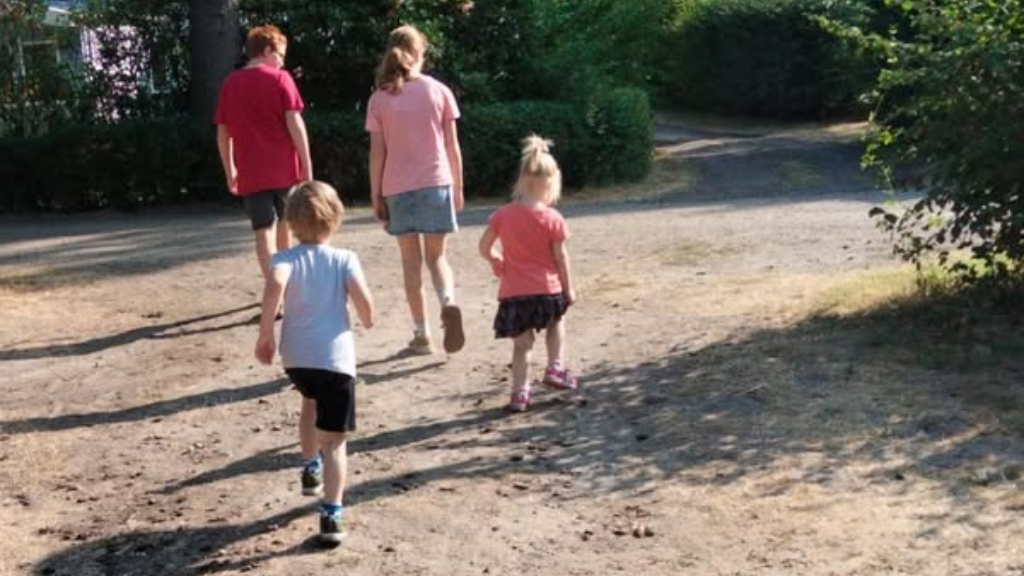 Vier kinderen wandelen door het zand