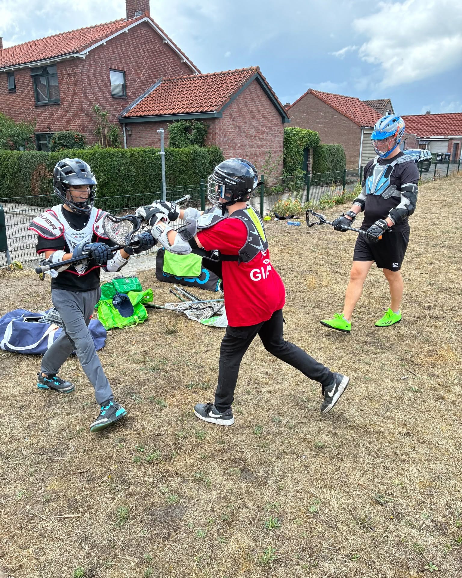 Jongeren oefenen met lacrosse ingepakt in de beschermende kleding